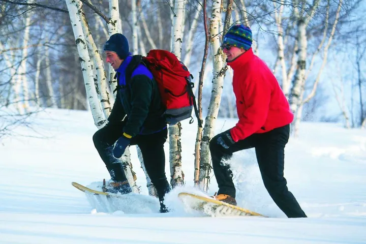 2 men snowshoeing through deep snow