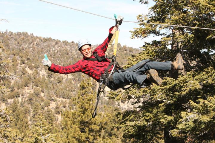 Man giving thumbs=up on zip-line