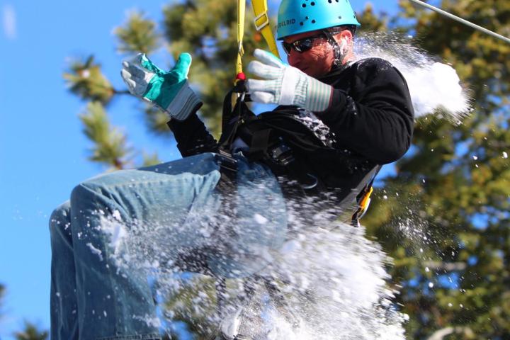 Man on zip-line being pelted with a snowball