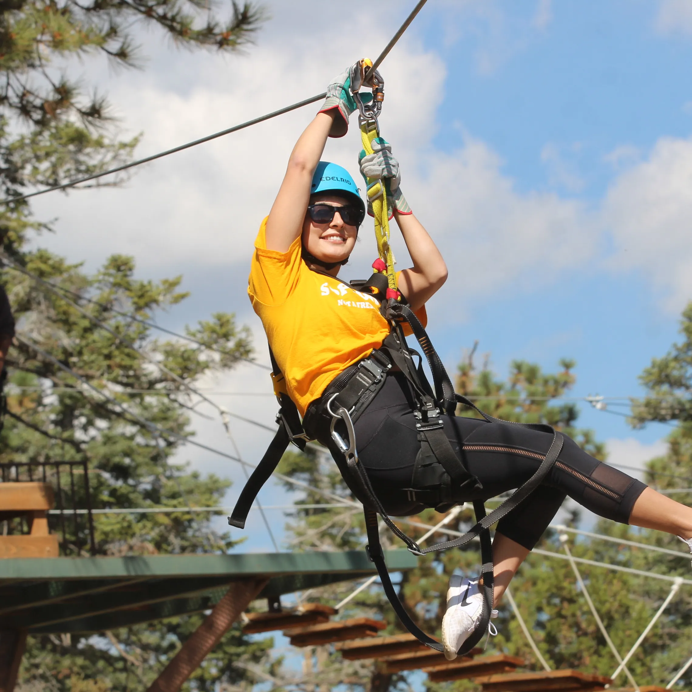 Woman jumping off of zip-line platform