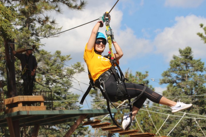 Woman jumping off of zip-line platform